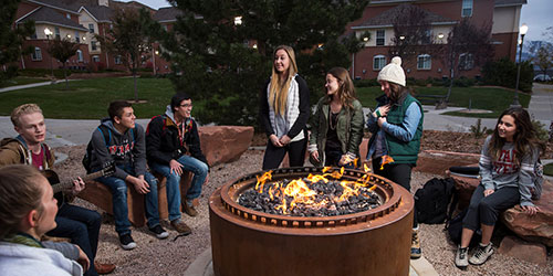 group of students gathered around firepit